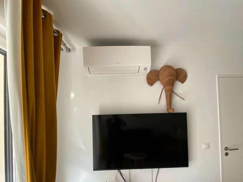Climatisation réversible au-dessus d’une télévision dans un salon à Nice